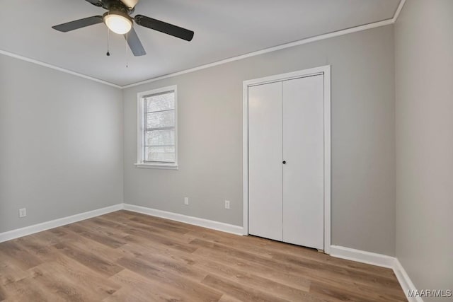 unfurnished bedroom featuring ceiling fan, a closet, light hardwood / wood-style floors, and ornamental molding