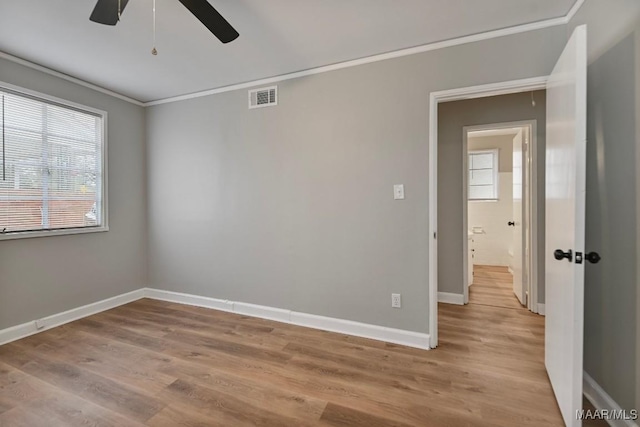 empty room featuring ceiling fan, light hardwood / wood-style floors, and ornamental molding