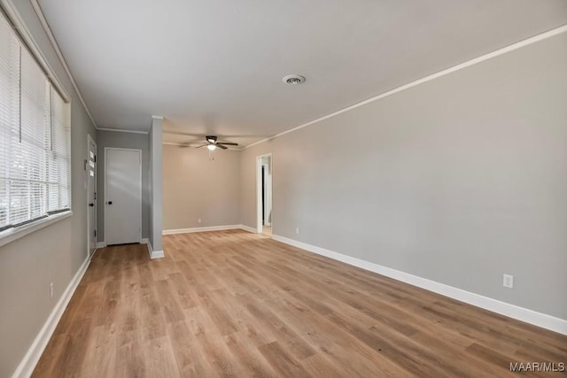 spare room featuring ceiling fan, light wood-type flooring, and ornamental molding