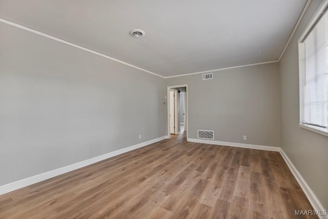 spare room featuring hardwood / wood-style floors and ornamental molding