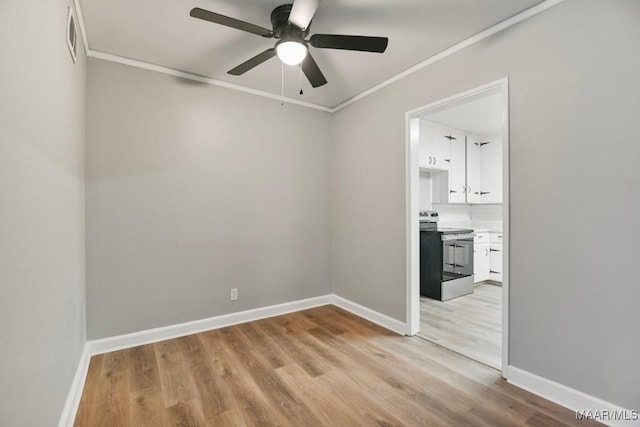 spare room featuring ceiling fan, light wood-type flooring, and crown molding