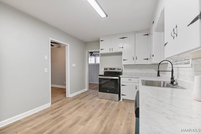 kitchen with decorative backsplash, stainless steel electric range oven, sink, light hardwood / wood-style floors, and white cabinetry