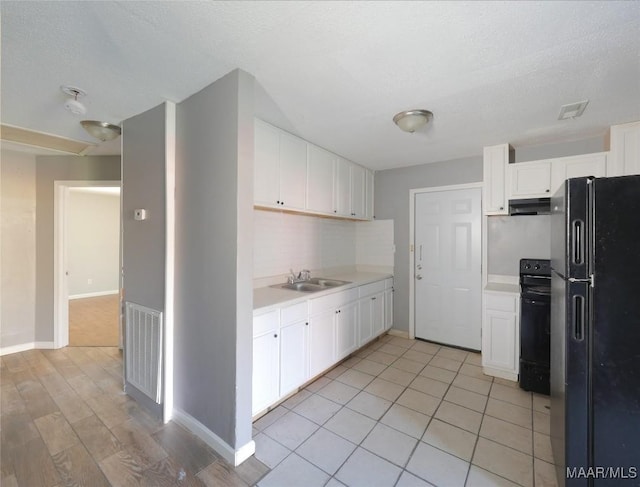 kitchen featuring backsplash, white cabinetry, sink, and black appliances