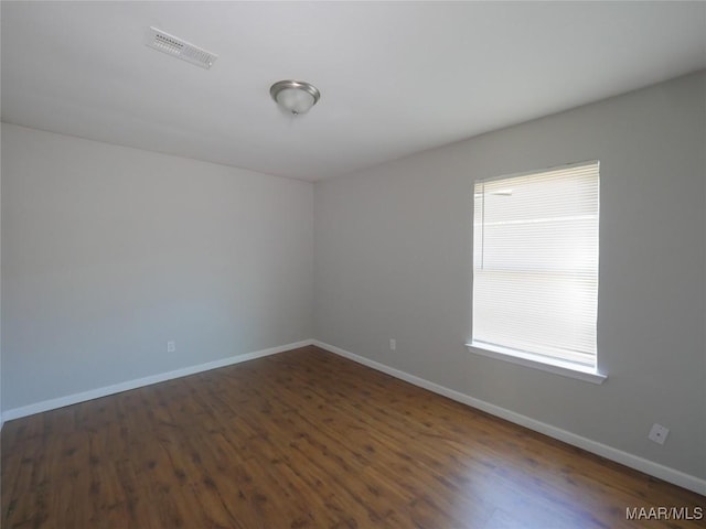 unfurnished room with a healthy amount of sunlight and dark hardwood / wood-style flooring