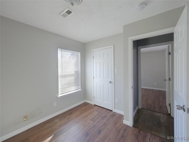 unfurnished bedroom featuring dark hardwood / wood-style flooring