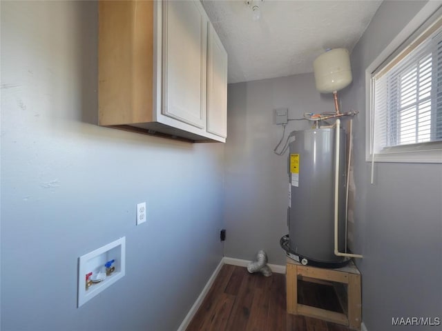 laundry area featuring water heater, dark hardwood / wood-style flooring, cabinets, and washer hookup