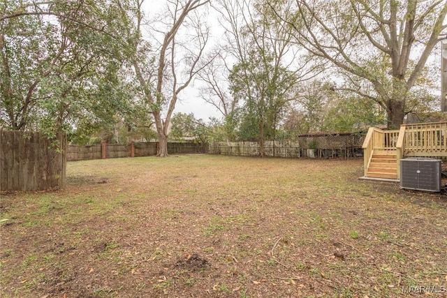 view of yard with central air condition unit and a wooden deck