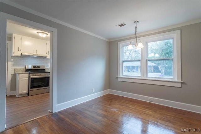 unfurnished dining area with a notable chandelier, dark hardwood / wood-style floors, and ornamental molding