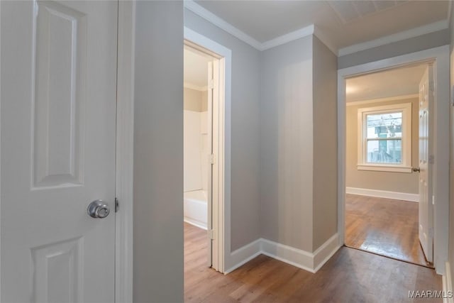 hallway with light hardwood / wood-style flooring and ornamental molding