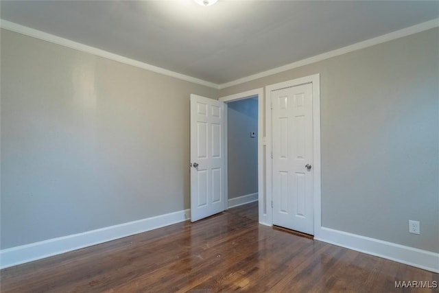 unfurnished room featuring crown molding and dark wood-type flooring