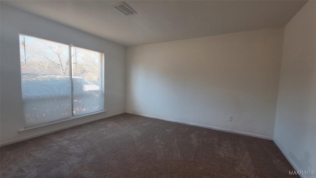 empty room featuring dark colored carpet