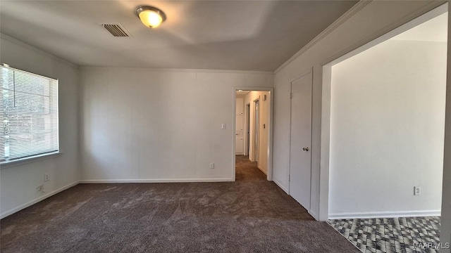 carpeted spare room featuring crown molding