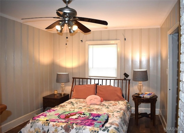 bedroom with ceiling fan, ornamental molding, and dark wood-type flooring