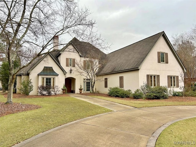 french provincial home with a front yard