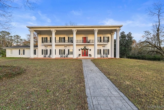 view of front facade with a balcony and a front lawn