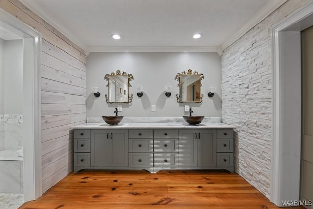 bathroom featuring vanity, wood-type flooring, and ornamental molding