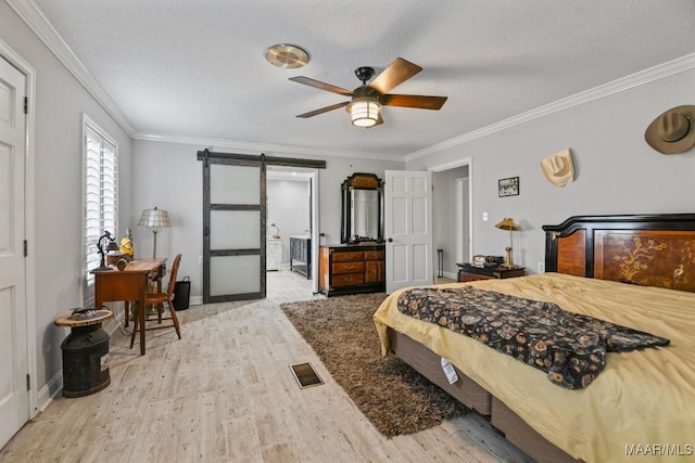 bedroom featuring a textured ceiling, ceiling fan, crown molding, a barn door, and light hardwood / wood-style floors