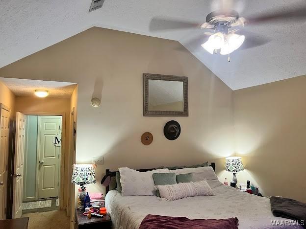 carpeted bedroom featuring a textured ceiling, ceiling fan, and vaulted ceiling