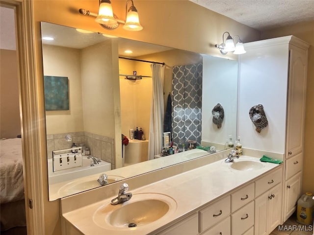 bathroom with vanity, a textured ceiling, and a tub