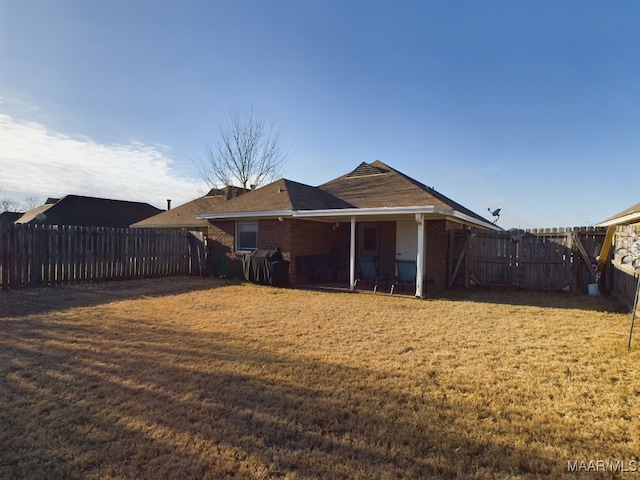 rear view of house featuring a lawn