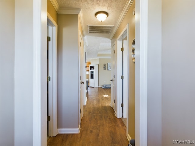 hall featuring crown molding, dark hardwood / wood-style flooring, and a textured ceiling