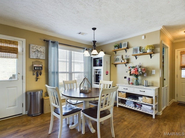 dining space with a textured ceiling, dark hardwood / wood-style floors, crown molding, and a notable chandelier