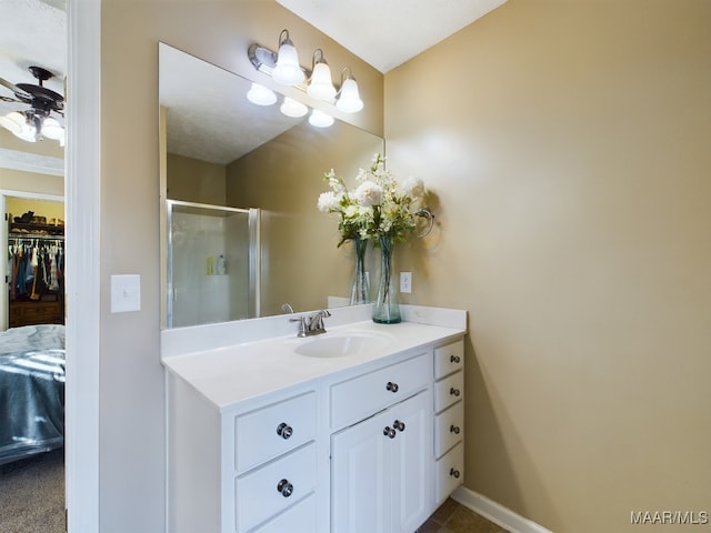 bathroom featuring vanity, ceiling fan, and an enclosed shower