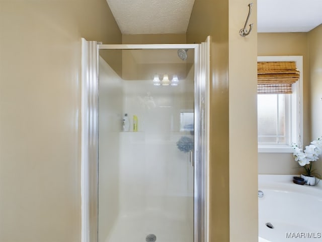 bathroom with a textured ceiling and independent shower and bath