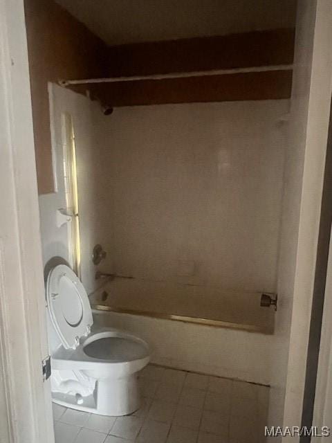 bathroom featuring tile patterned floors, tiled shower / bath combo, and toilet