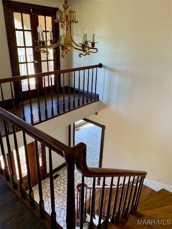 stairway featuring a chandelier and french doors