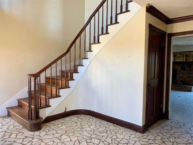 stairs with crown molding and a textured ceiling