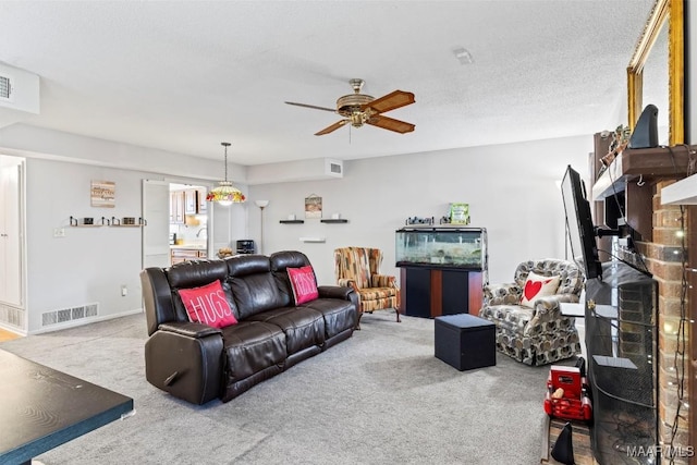 living room featuring carpet, a textured ceiling, ceiling fan, and a fireplace