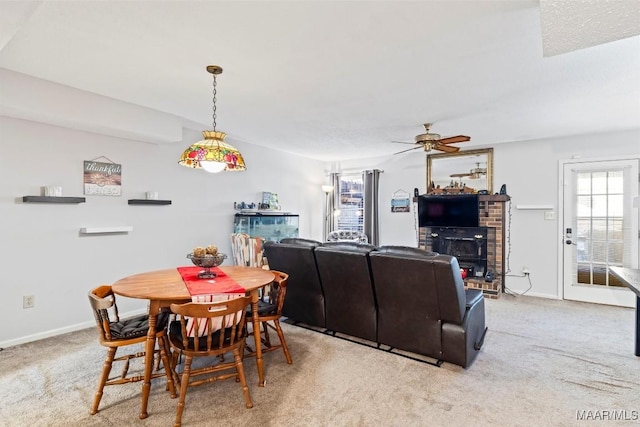 dining area featuring ceiling fan, light colored carpet, and a healthy amount of sunlight