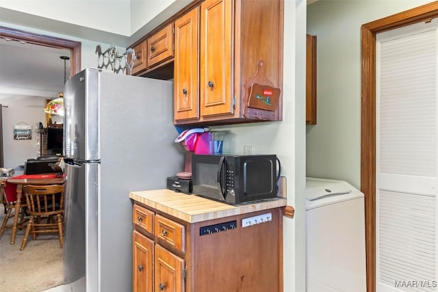 kitchen featuring washer / clothes dryer, stainless steel fridge, and carpet