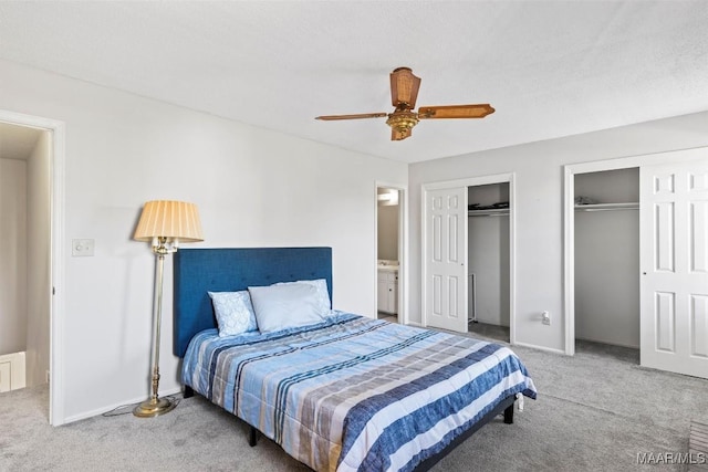 bedroom with carpet flooring, ceiling fan, and multiple closets