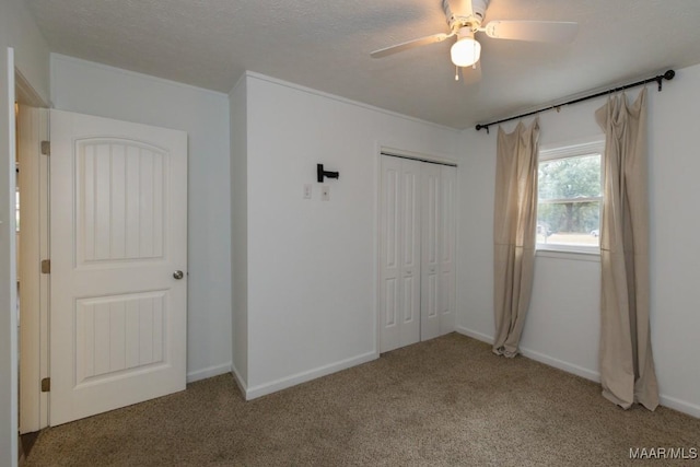 unfurnished bedroom with carpet flooring, ceiling fan, a closet, and a textured ceiling