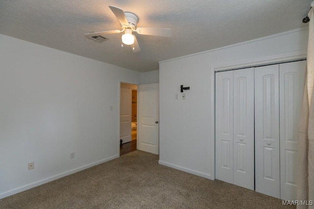 unfurnished bedroom with carpet flooring, a textured ceiling, a closet, and ceiling fan