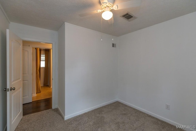 carpeted empty room with ceiling fan and a textured ceiling