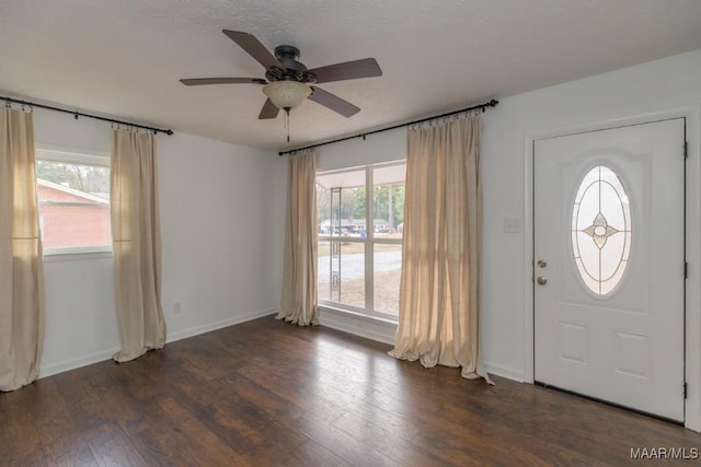 entrance foyer featuring a textured ceiling, ceiling fan, and dark wood-type flooring