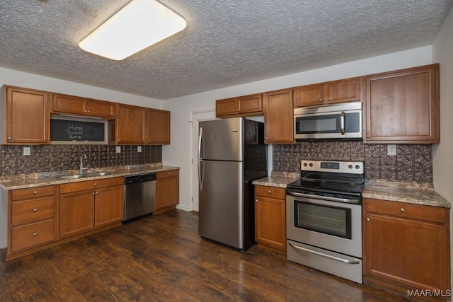 kitchen with stone counters, sink, dark hardwood / wood-style flooring, decorative backsplash, and appliances with stainless steel finishes