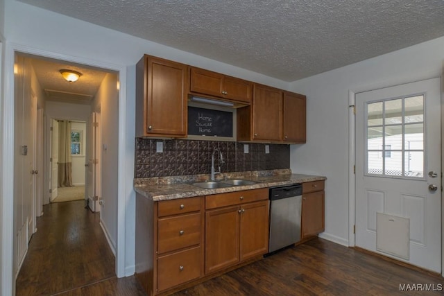 kitchen with dishwasher, sink, dark hardwood / wood-style floors, a textured ceiling, and decorative backsplash