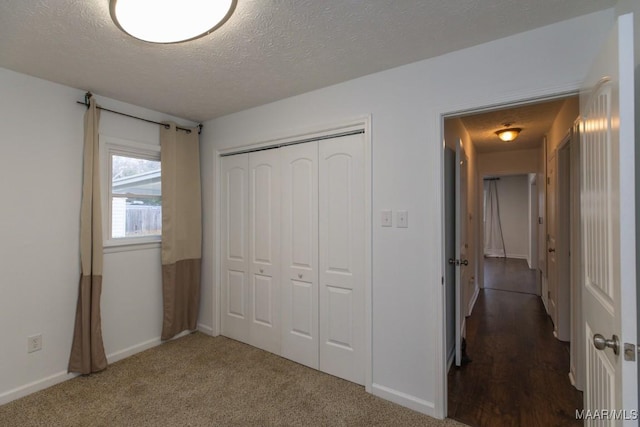 unfurnished bedroom with carpet flooring, a textured ceiling, and a closet