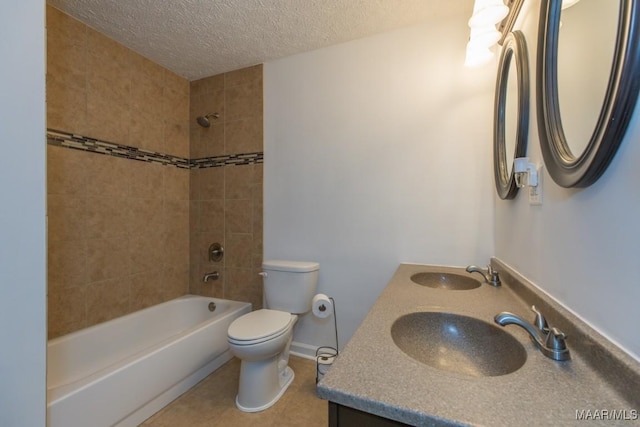 full bathroom with a textured ceiling, vanity, tile patterned flooring, toilet, and tiled shower / bath