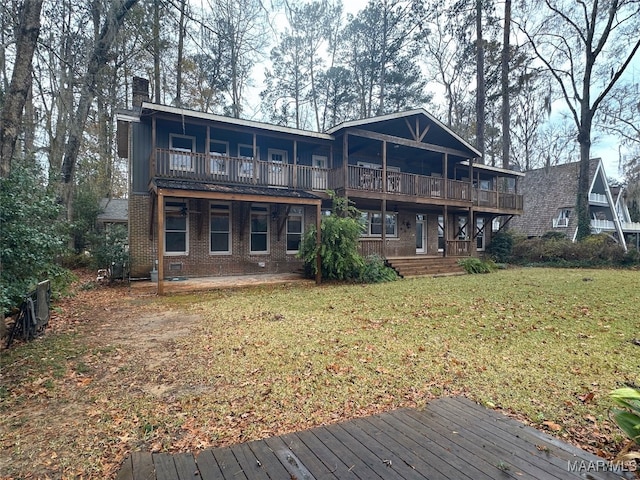 back of house featuring a balcony, a wooden deck, and a lawn