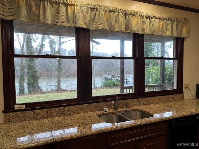 kitchen featuring dishwasher, a water view, sink, crown molding, and light stone counters