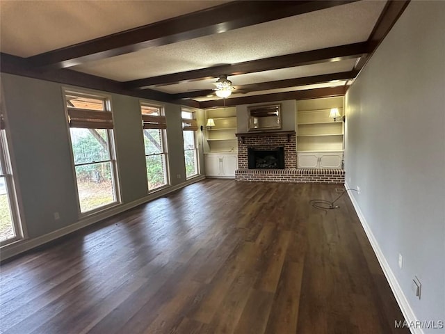 unfurnished living room featuring beam ceiling, ceiling fan, built in features, and dark hardwood / wood-style floors