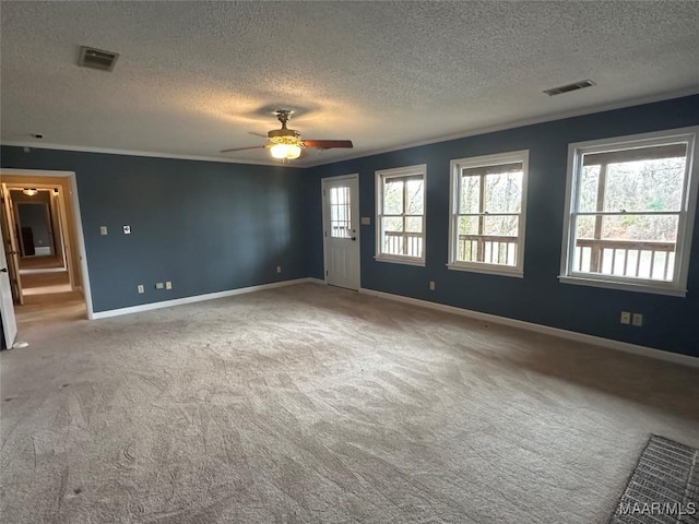 carpeted spare room with a textured ceiling, ceiling fan, and crown molding