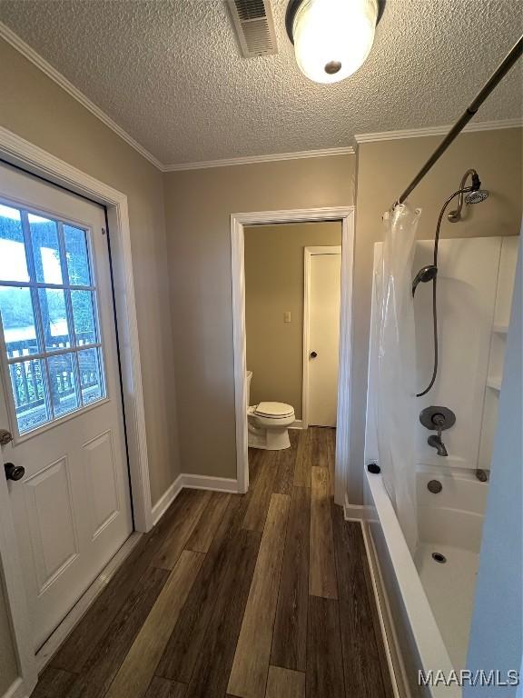 bathroom with curtained shower, hardwood / wood-style floors, a textured ceiling, and toilet