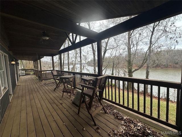 deck with a water view and ceiling fan