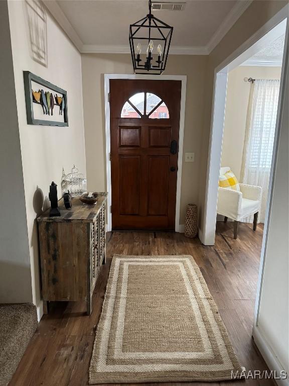 entrance foyer with a notable chandelier, dark wood-type flooring, and a wealth of natural light